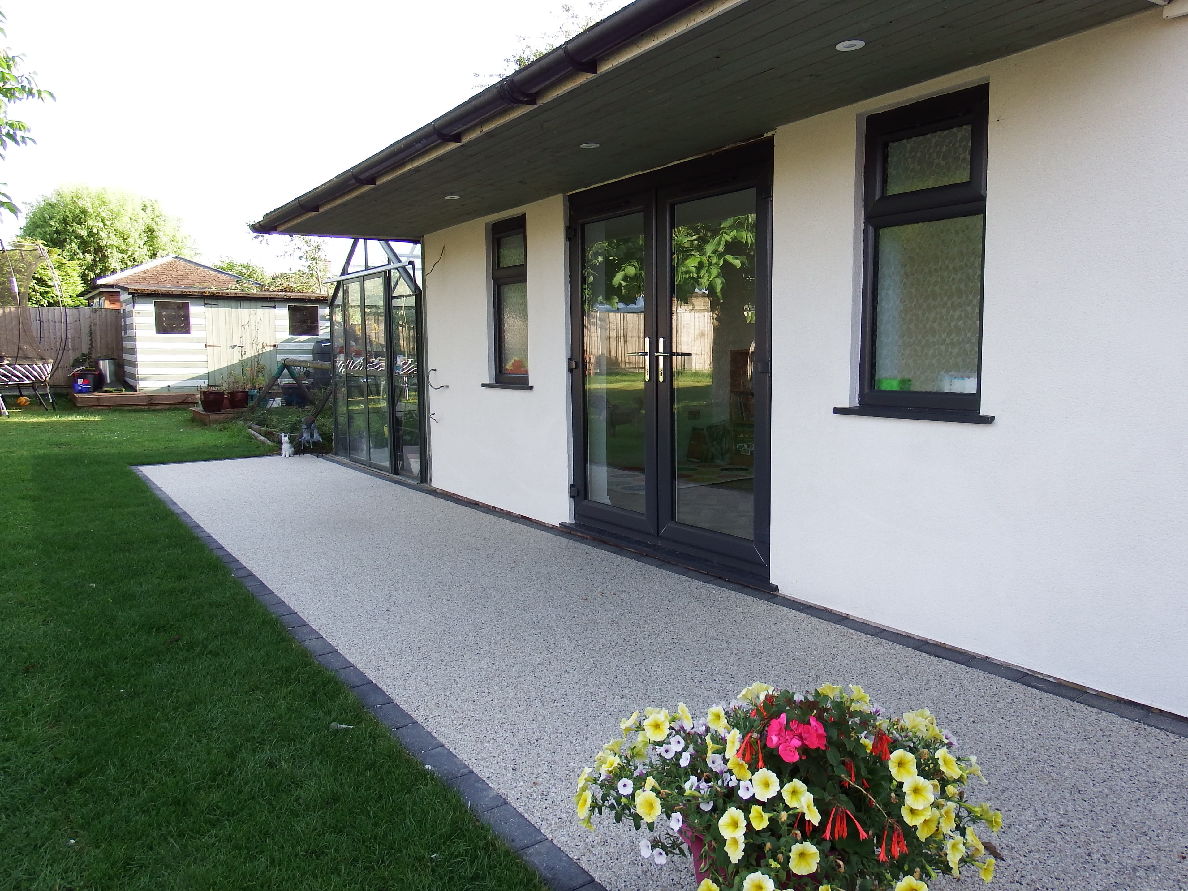 The DEN building entrance with garden flowers